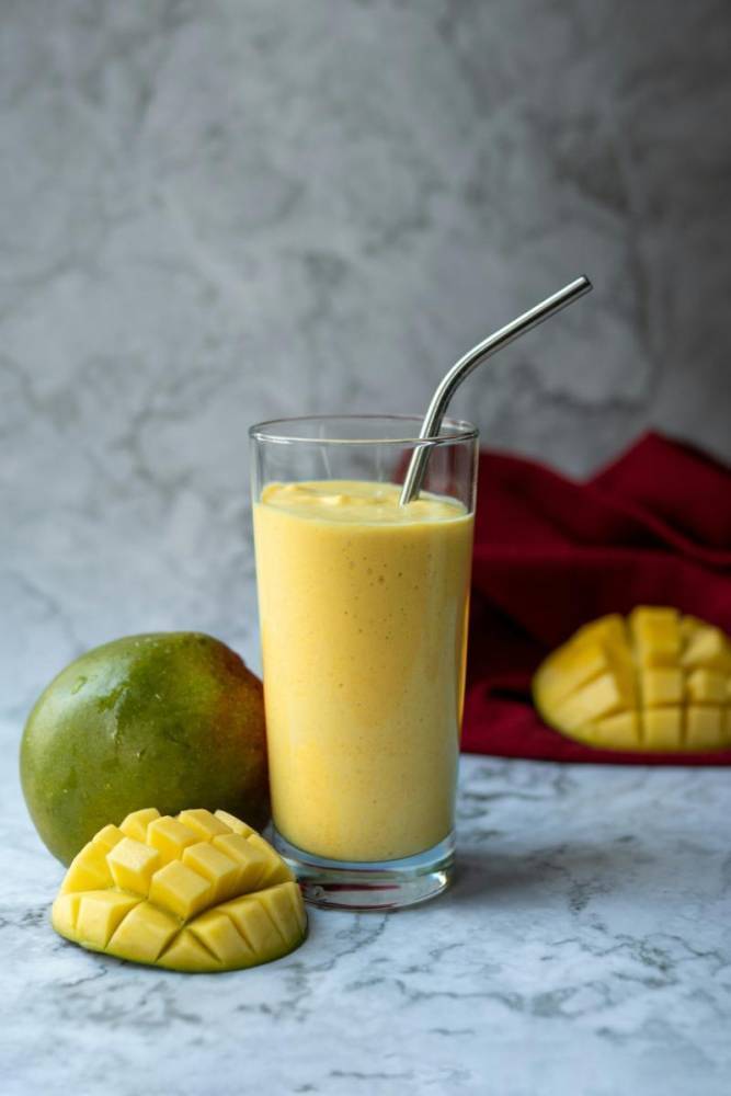 mango smoothie served with straw and mint